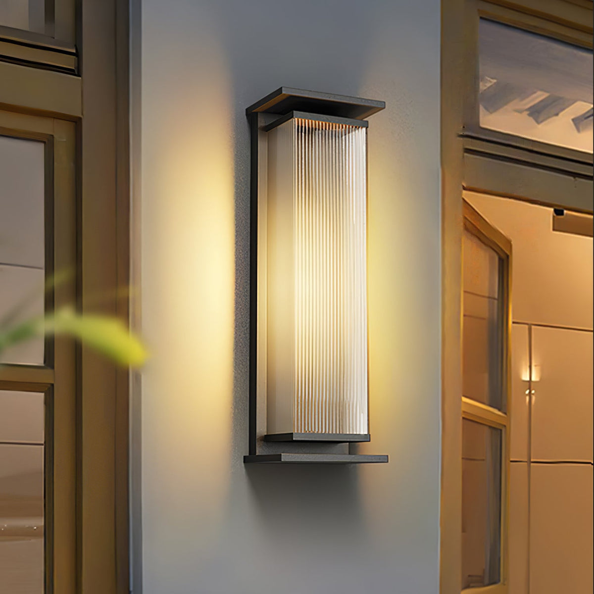 A Clérachic wall light centred between two glazed doors, its ribbed shade glowing warm in a black frame.