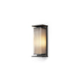 A short Clérachic wall light with a ribbed shade glowing white, in a black frame on a plain white backdrop.