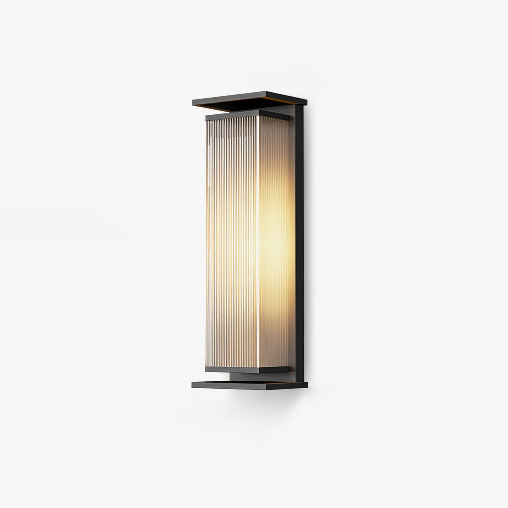 A mid-height Clérachic wall light with a black frame and glowing ribbed shade, on a pale backdrop.