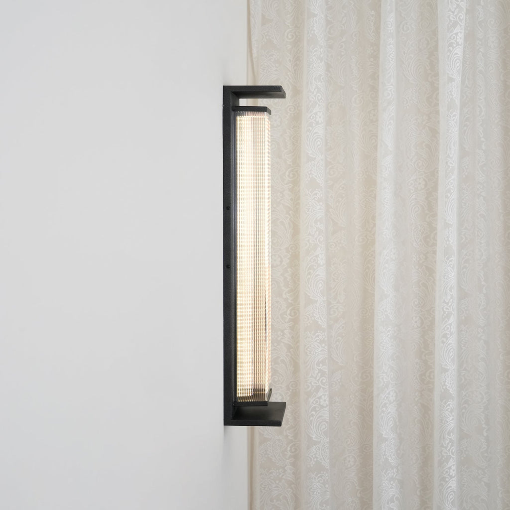 Side view of this Clérachic wall light, showing how far the black frame and ribbed shade stand out from the wall.