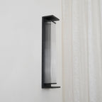 Side view of this Clérachic wall light, unlit, with clear ribbed glass and a black base shelf.