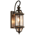 Studio view of the Clérachic wall lantern lit on white, showing the backplate, hooked arm and pointed bottom finial.