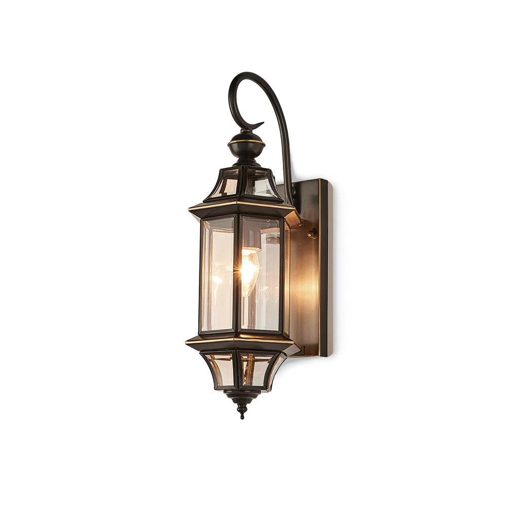 A smaller Clérachic wall lantern shown whole on white, with a lit bulb inside clear glass panels and a curved black arm.