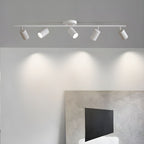 A white Clérachic five-head track light on a grey ceiling casts scalloped pools of light over a large abstract canvas.