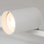 Close view of one white Clérachic spotlight head, showing the lit bulb recessed inside its cylinder.