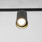 Close view of a black Clérachic spotlight head with a bright bulb inside a gold-lined cylinder.