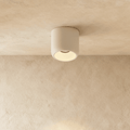 Clérachic downlight in white, a compact cylinder surface-mounted on the ceiling and casting a soft warm pool of light.
