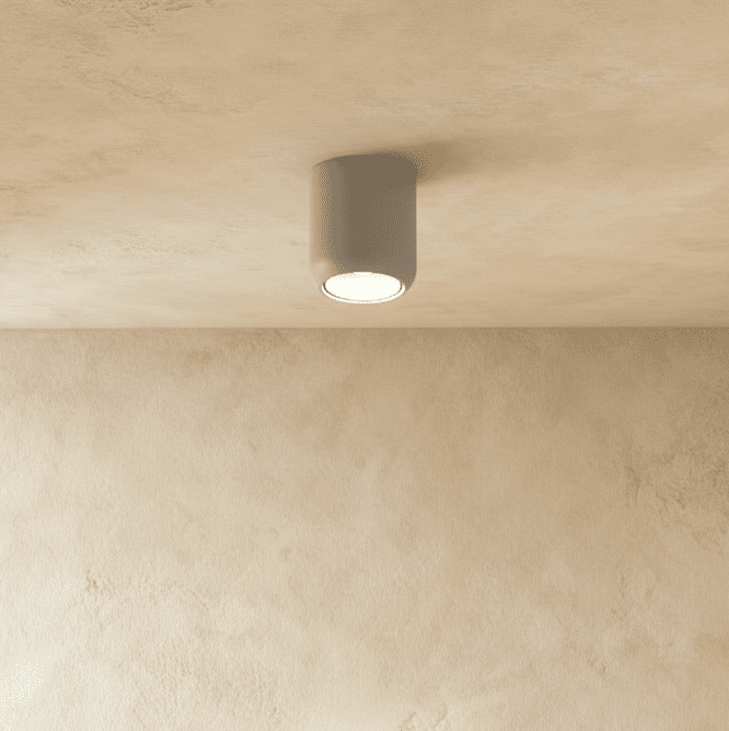 Clérachic downlight in white, its cylindrical body angled slightly against a plaster ceiling, unlit interior visible.