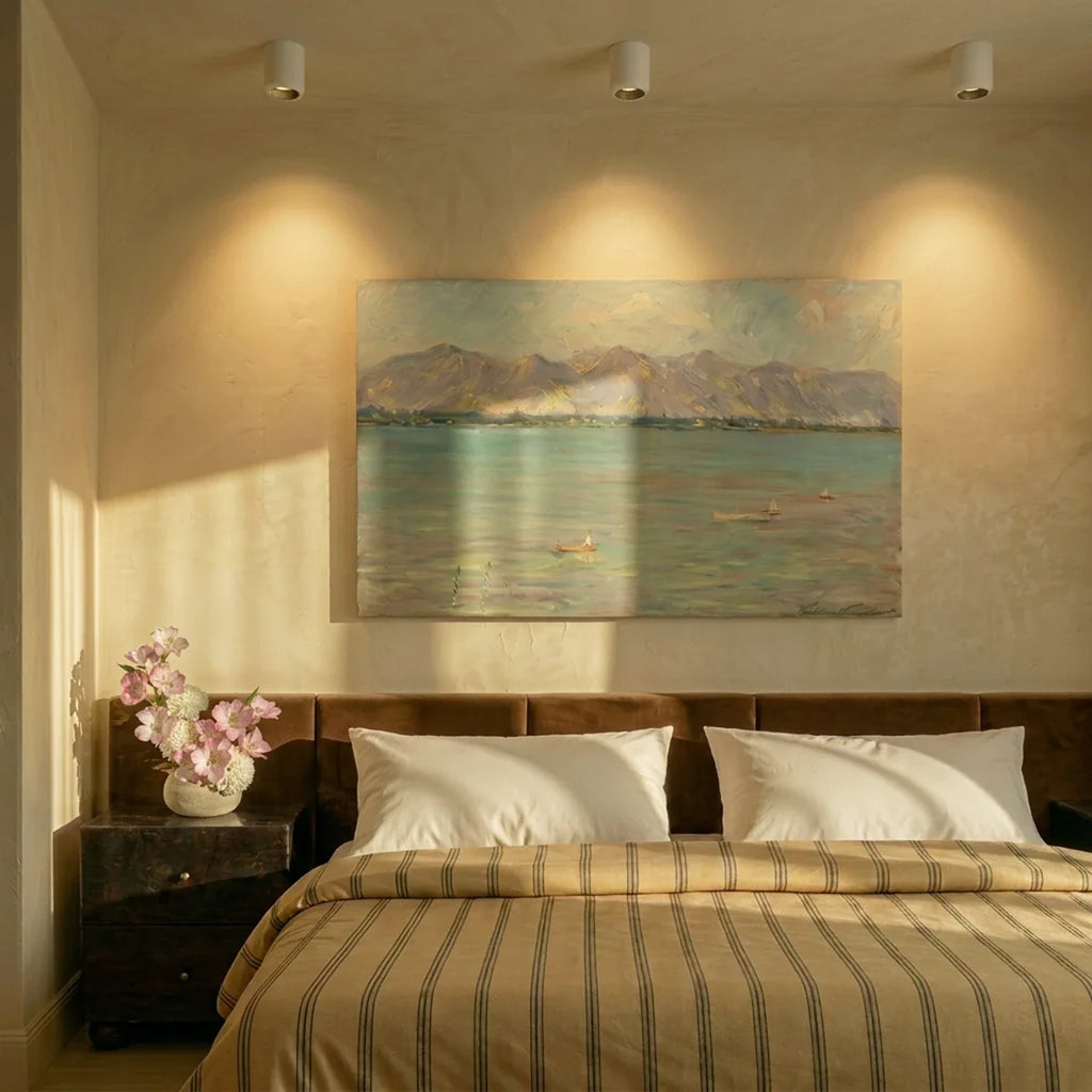 Three Clérachic downlights in white spotlighting a framed seascape painting above a bed with striped linen.