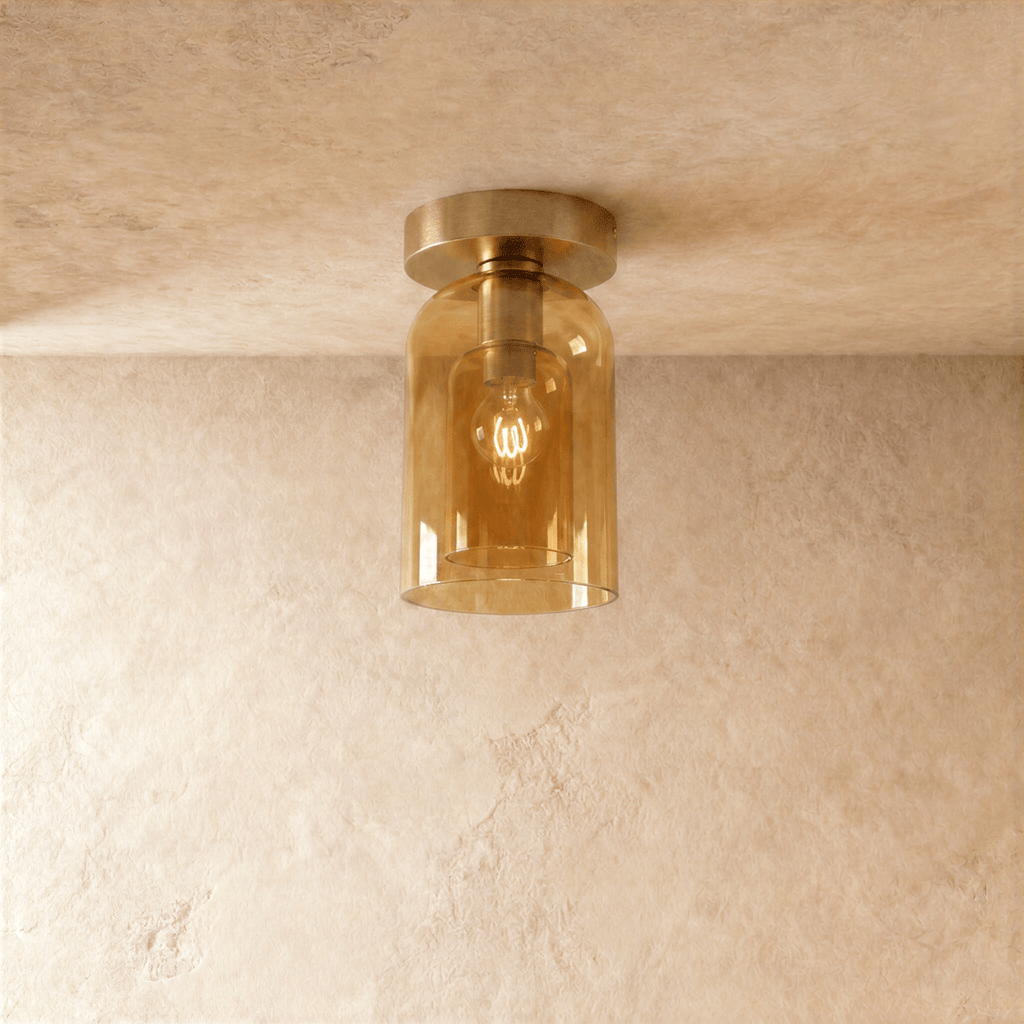 Clérachic amber glass cylinder ceiling light flush-mounts with a gold fitter, filament bulb glowing inside.