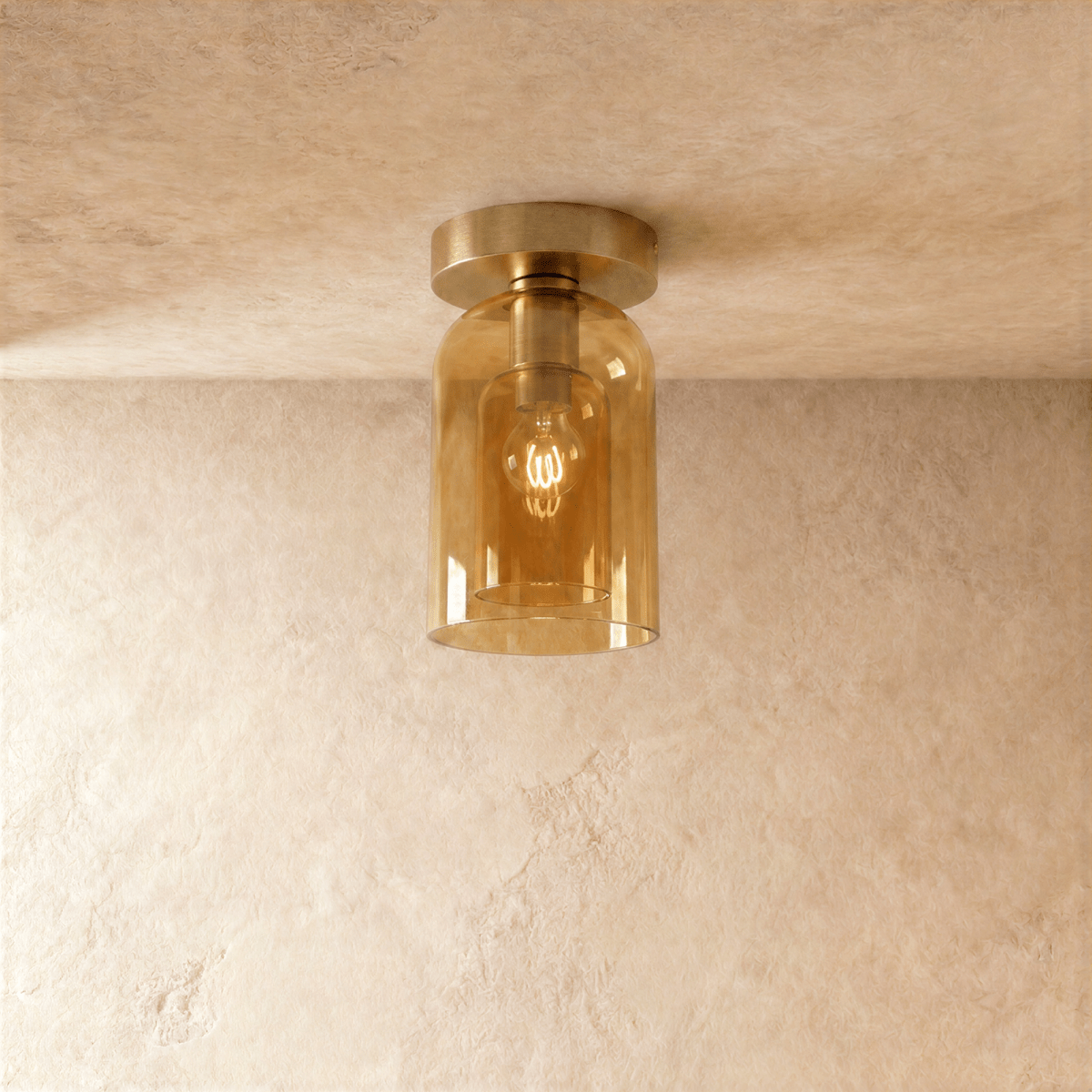 Clérachic amber glass cylinder ceiling light flush-mounts with a gold fitter, filament bulb glowing inside.