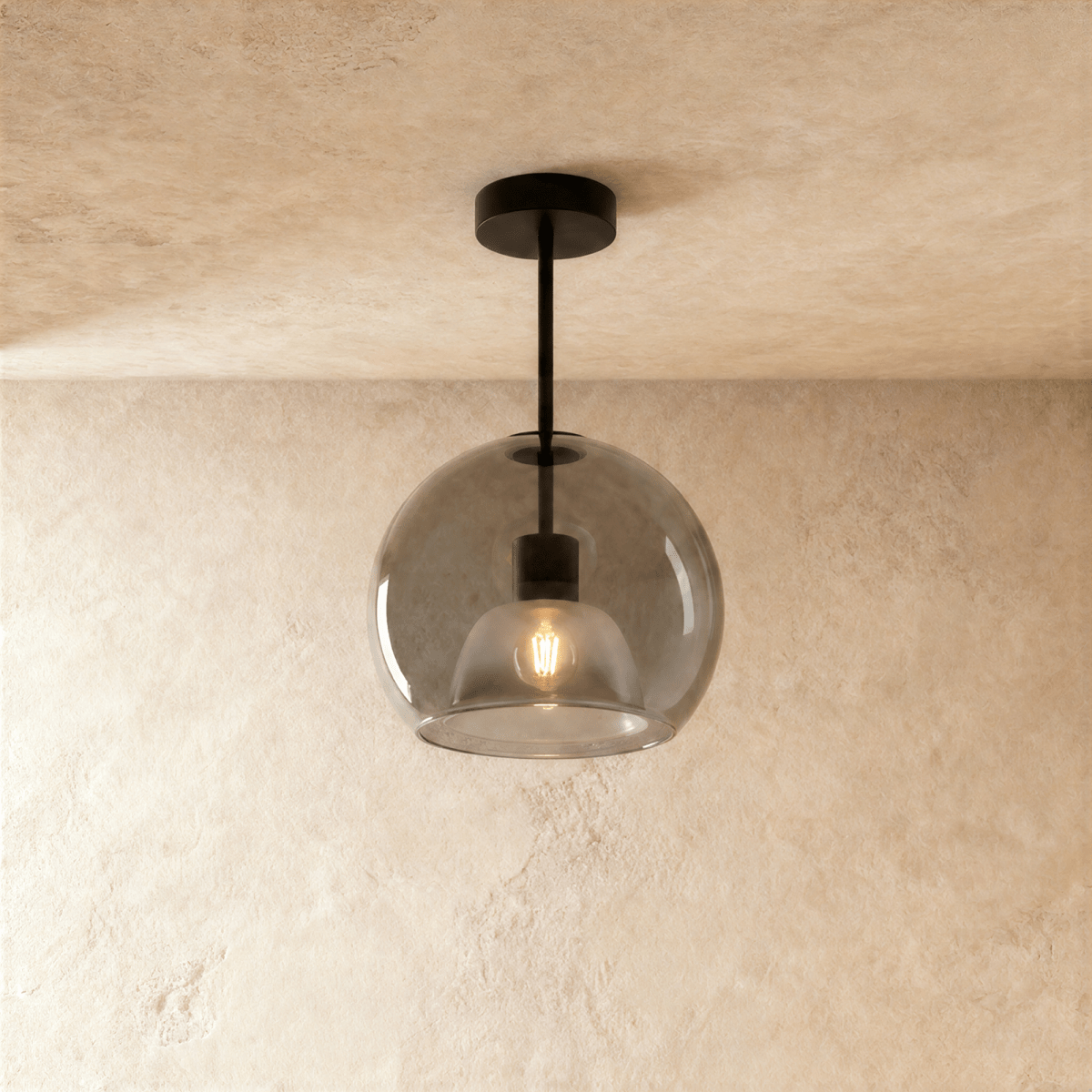 Clérachic smoked glass globe pendant drops on a black rod, its inner dome shade lit warm against the glass.