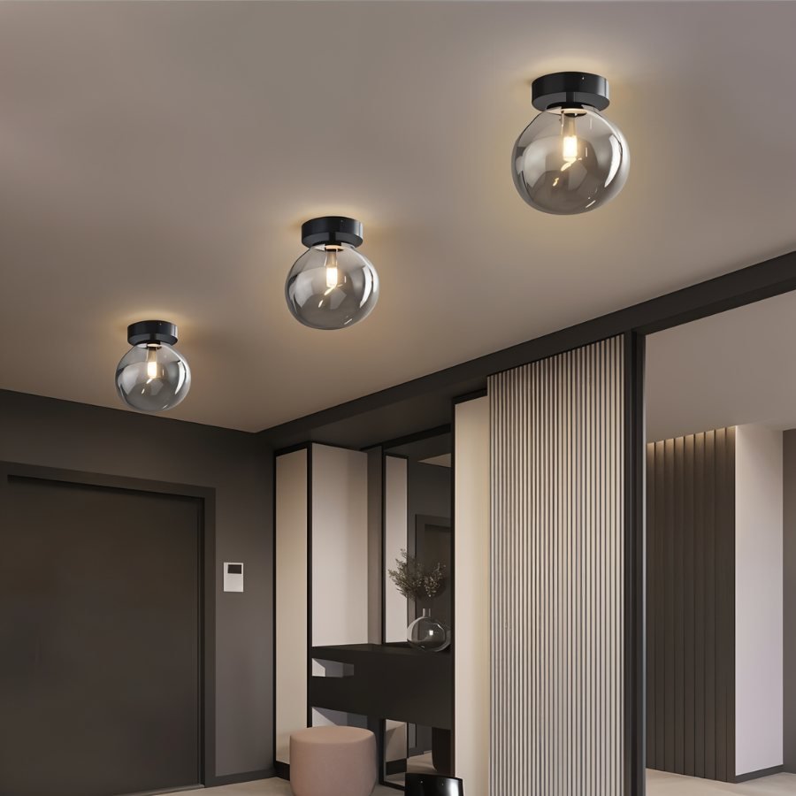 Clérachic smoked glass globe ceiling lights flush-mount in a row, lighting a dark modern entry hallway.
