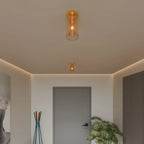 Clérachic amber glass cylinder ceiling lights, one pendant and one flush-mount, warm a hallway in gold.