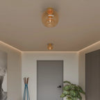 Clérachic amber hand-blown glass globes, pendant and flush-mount, light a hallway with gold hardware.