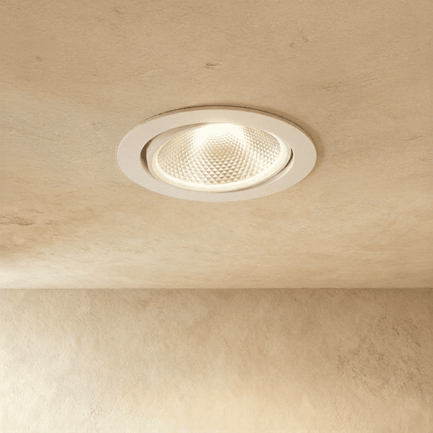 Clérachic downlight in white, the tiltable round trim glowing warm white against a plaster ceiling.