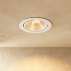Clérachic downlight in white, its faceted reflector casting a warm glow from an adjustable round trim.