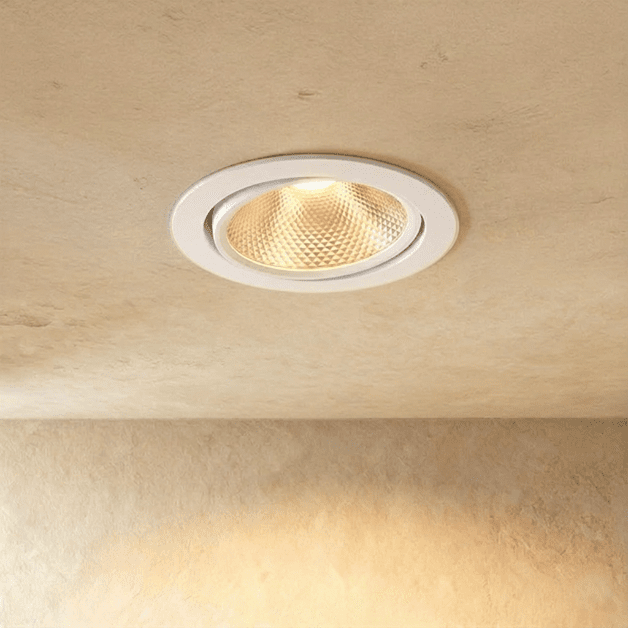 Clérachic downlight in white, its faceted reflector casting a warm glow from an adjustable round trim.
