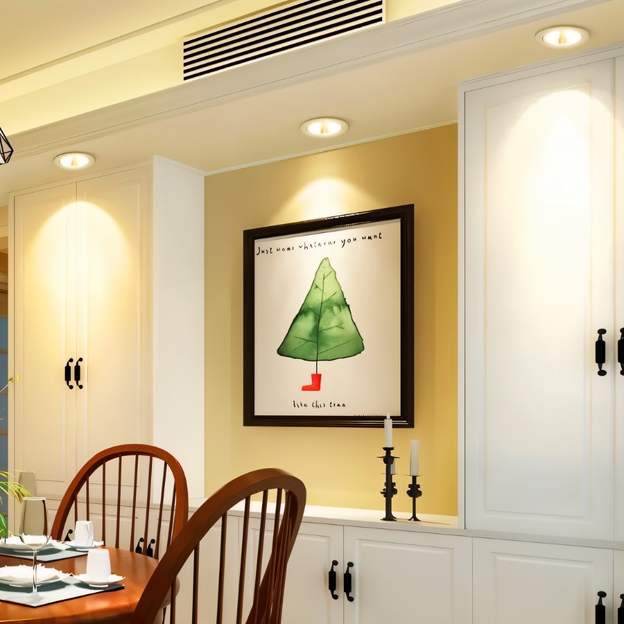Clérachic downlights in white recessed above cream cabinetry, lighting a framed illustrated print in a dining nook.