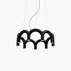 A black tiered-arch Clérachic chandelier on a soft off-white backdrop, hung on three cables.
