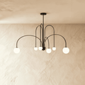 This Clérachic black Art Deco chandelier spreads its looped arms wide, each ending in a round glass globe.