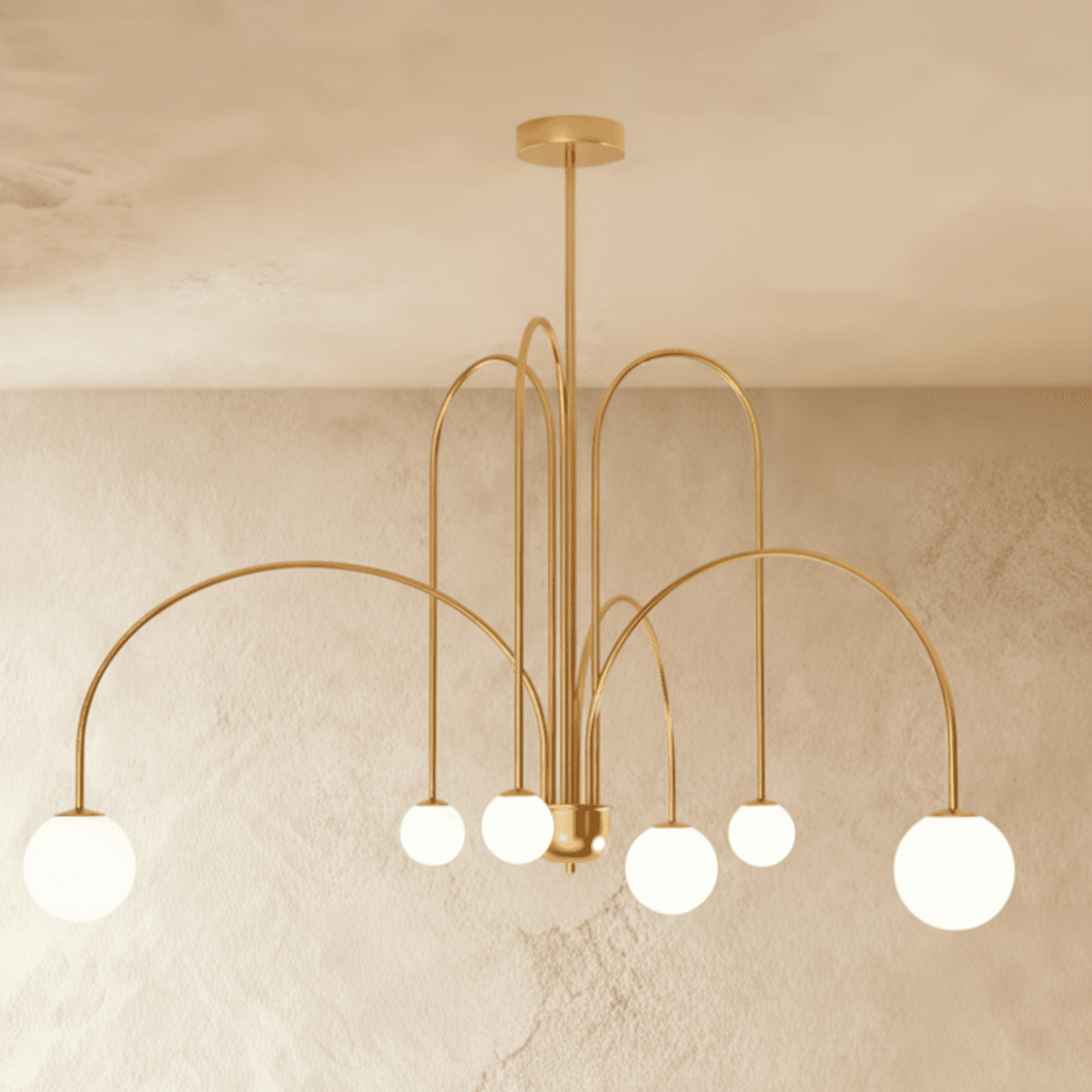 This Clérachic gold Art Deco chandelier hangs with looped brass-toned arms and six round glass globes.