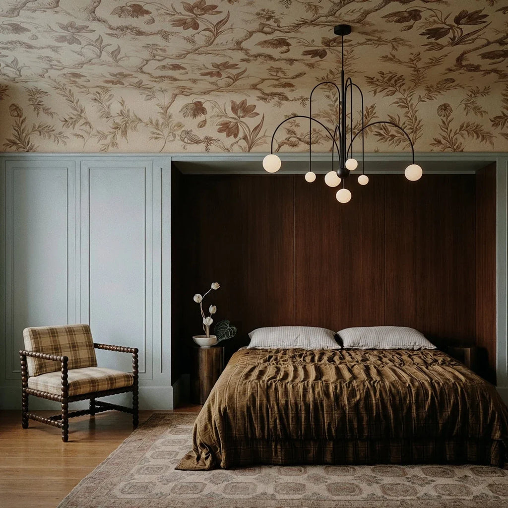 This Clérachic black Art Deco chandelier lights a bedroom nook framed by dark wood paneling and pale blue walls.