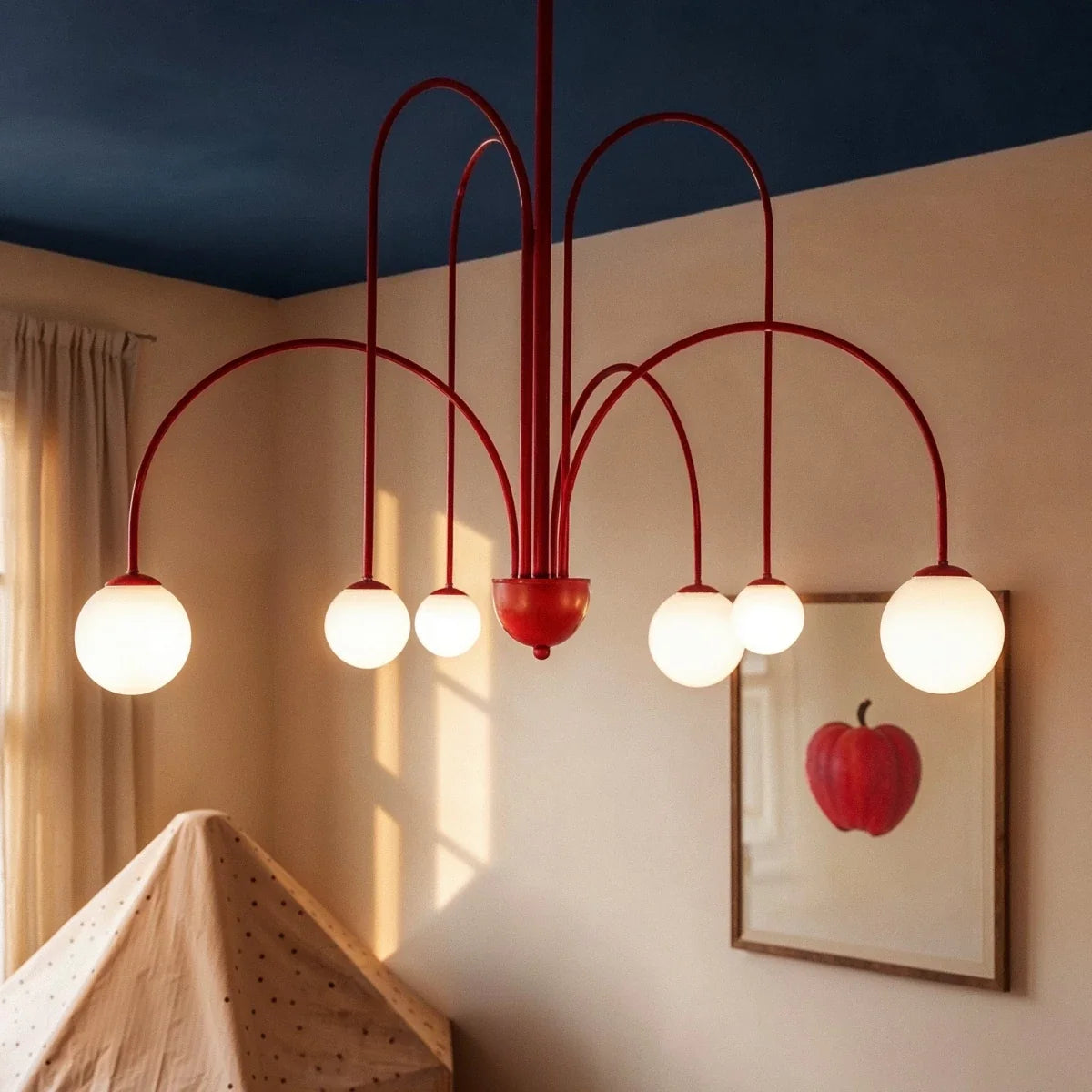 A close view shows the Clérachic red chandelier's curved arms and glass globes above a child's play tent.