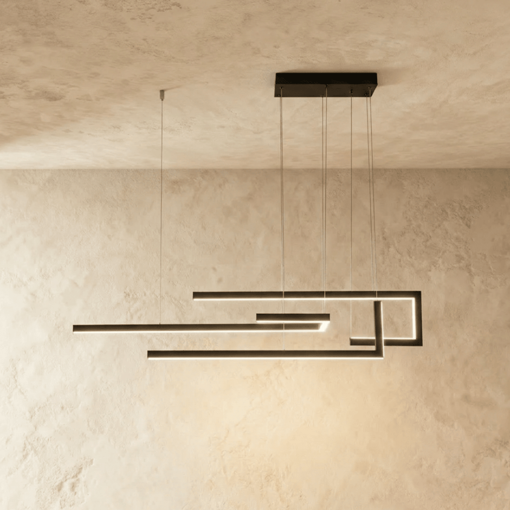 A side view of the Clérachic chandelier in black, its geometric LED bars glowing cool white overhead.