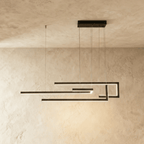 A side view of the Clérachic chandelier in black, its geometric LED bars glowing cool white overhead.