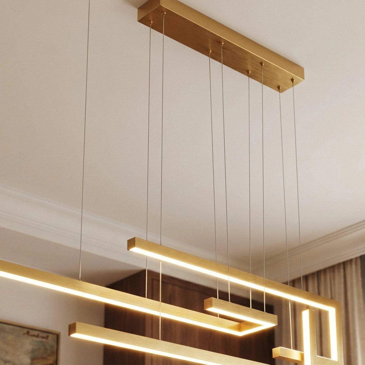 A close detail of the Clérachic chandelier in gold, showing its ceiling canopy and suspension cables.
