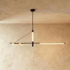 Clérachic black linear chandelier hung from a round ceiling plate, a vertical LED tube and a long LED bar lit warm against plaster.