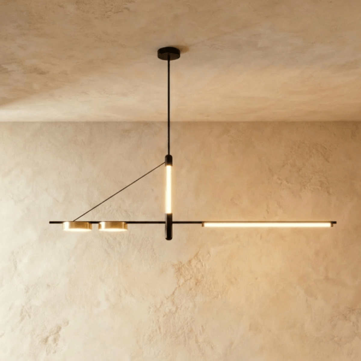 Clérachic black linear chandelier hung from a round ceiling plate, a vertical LED tube and a long LED bar lit warm against plaster.