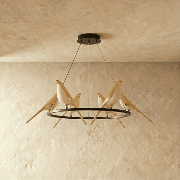 Clérachic ring chandelier with gold bird figures perched on a black hoop, shown unlit against a textured plaster wall.
