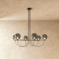 Clérachic six-globe chandelier with smoky grey glass shades on a black iron armature, lit, hung from slim black cords.