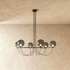 Clérachic six-globe chandelier with smoky grey glass shades on a black iron armature, lit, hung from slim black cords.
