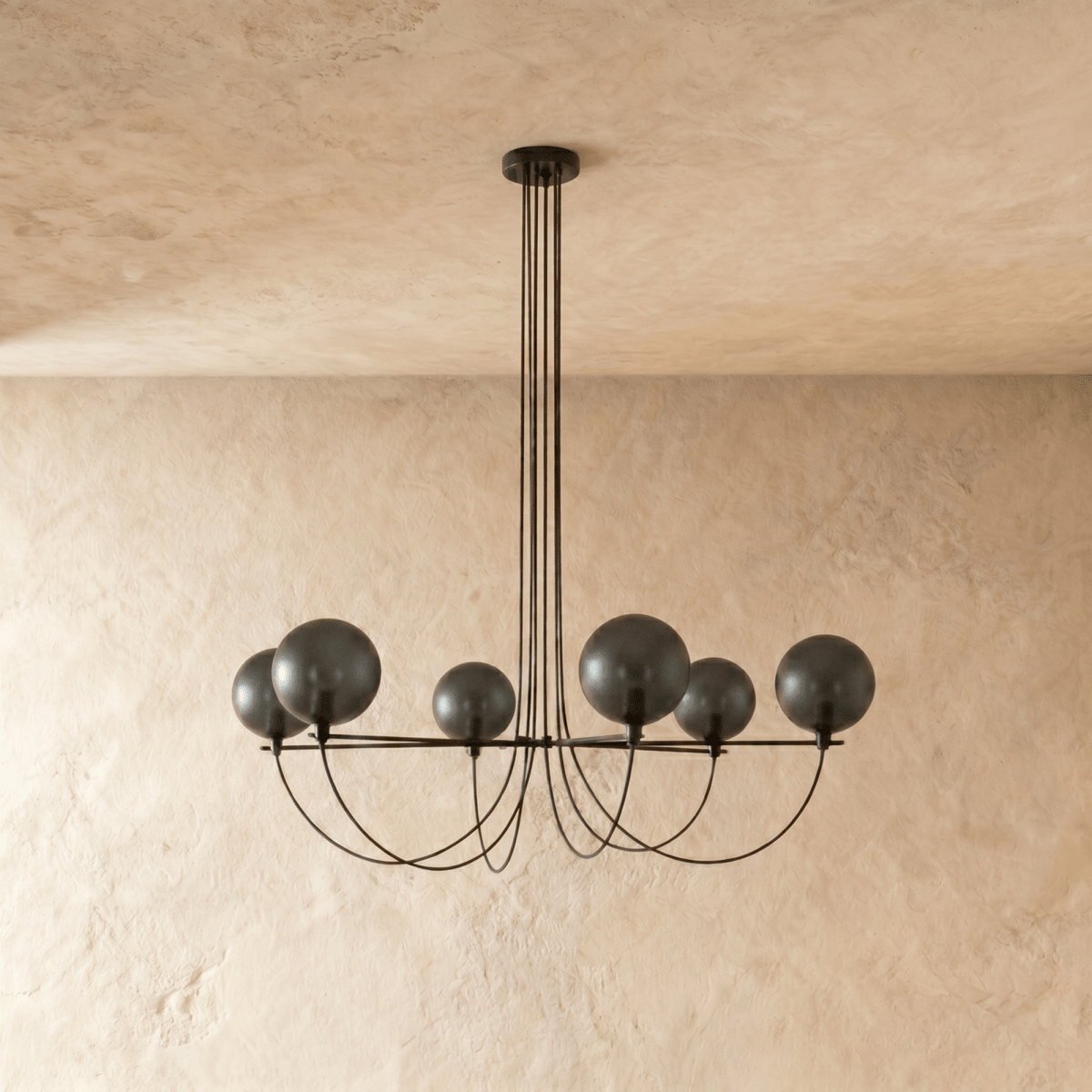 Clérachic six-globe chandelier unlit, showing dark smoky glass shades on a black iron armature with draped cords.