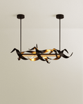 Clérachic black ribbon chandelier with a glowing LED bar, hung on two slim rods from black canopies against a soft beige wall.
