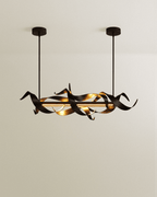 Clérachic black ribbon chandelier with a glowing LED bar, hung on two slim rods from black canopies against a soft beige wall.