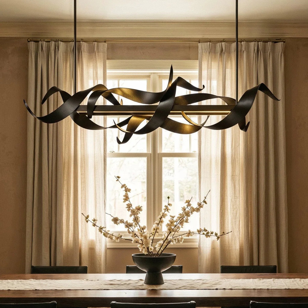 Clérachic black ribbon chandelier hanging in front of a sash window with linen curtains above a dining table and blossom bowl.