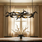 Clérachic black ribbon chandelier hanging in front of a sash window with linen curtains above a dining table and blossom bowl.
