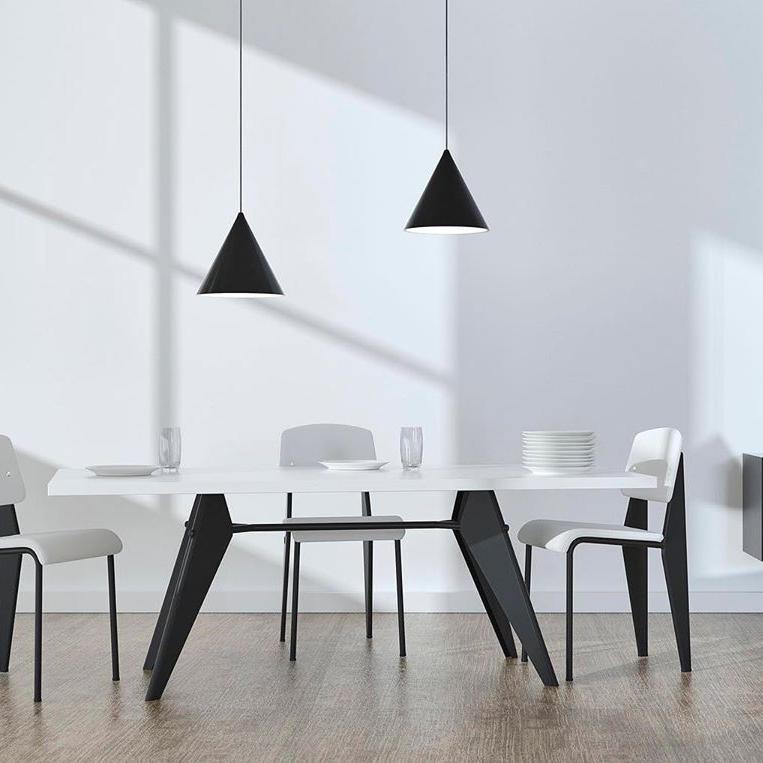 Two Clérachic cone pendants in black over a white dining table with black-legged chairs and a pale wooden floor.