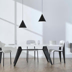Two Clérachic cone pendants in black over a white dining table with black-legged chairs and a pale wooden floor.