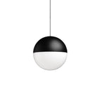 A Clérachic sphere pendant on a white backdrop, its upper half black and its lower half frosted white, hung from a thin cable.
