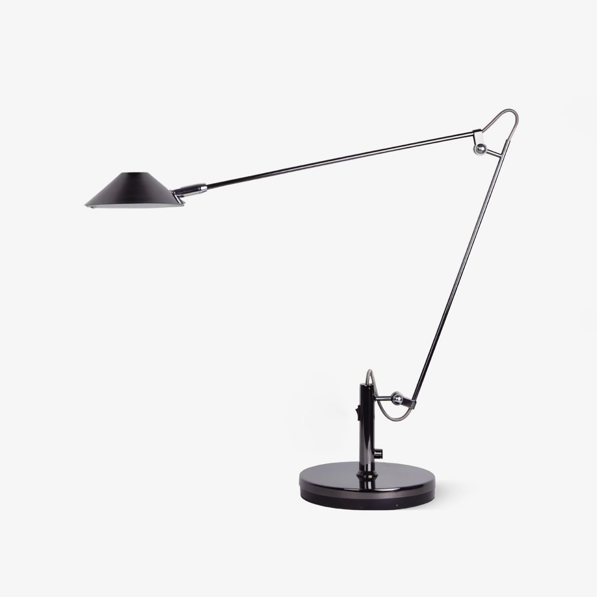 A Clérachic black adjustable lamp on a round base, with a long jointed arm and a flat cone shade, on a plain white background.