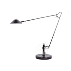 A Clérachic black arm lamp with its cone shade pointing left and a looped hinge on the right, on a white background.