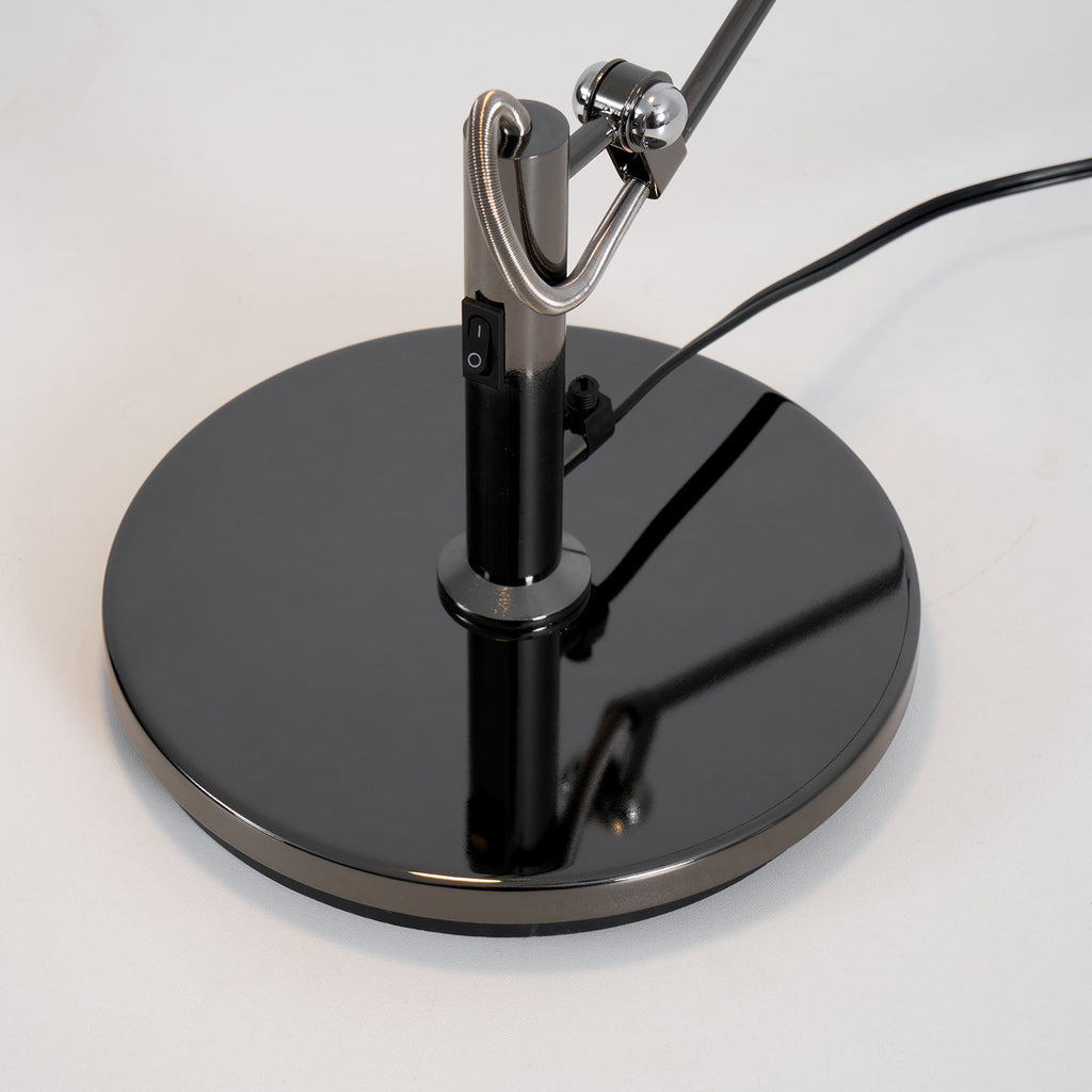 Looking down on the glossy round base of this Clérachic black arm lamp, showing the inline rocker switch and cord.