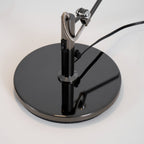 Looking down on the glossy round base of this Clérachic black arm lamp, showing the inline rocker switch and cord.