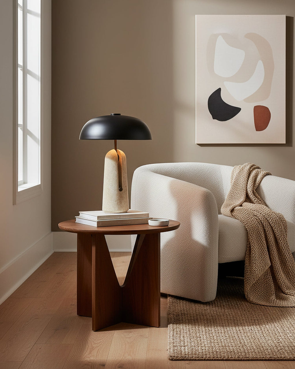 Tall view of this Clérachic table lamp on a walnut side table, with a cream armchair and a knitted throw behind.