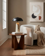Tall view of this Clérachic table lamp on a walnut side table, with a cream armchair and a knitted throw behind.